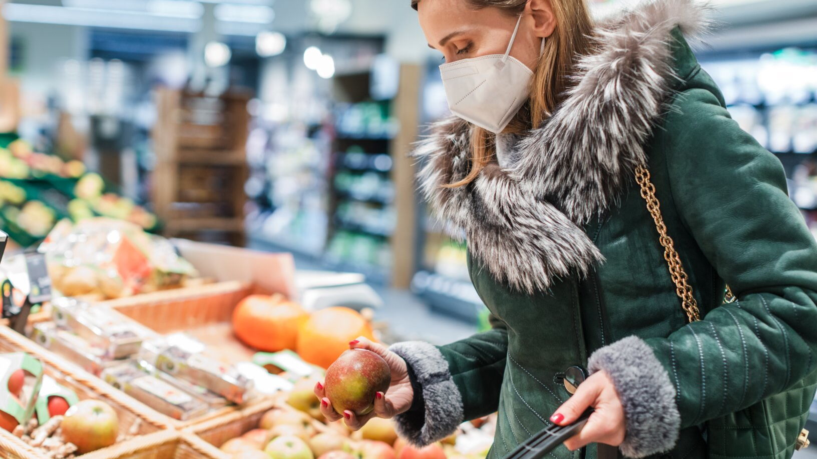 Ein Frau kauft mit Mundschutz in einem Supermarkt ein