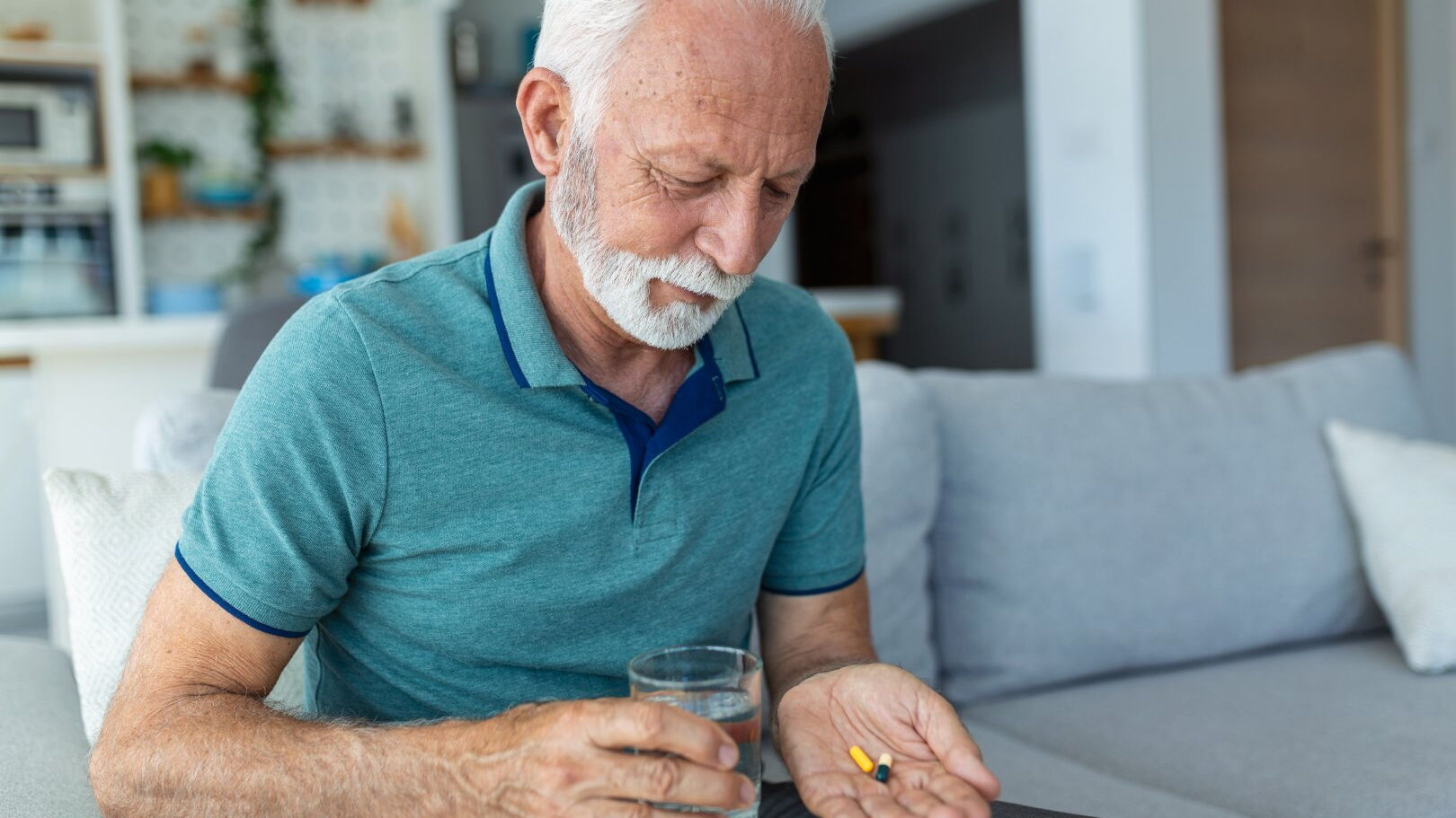 Mann fühlt sich depressiv und nimmt Medikamente ein.